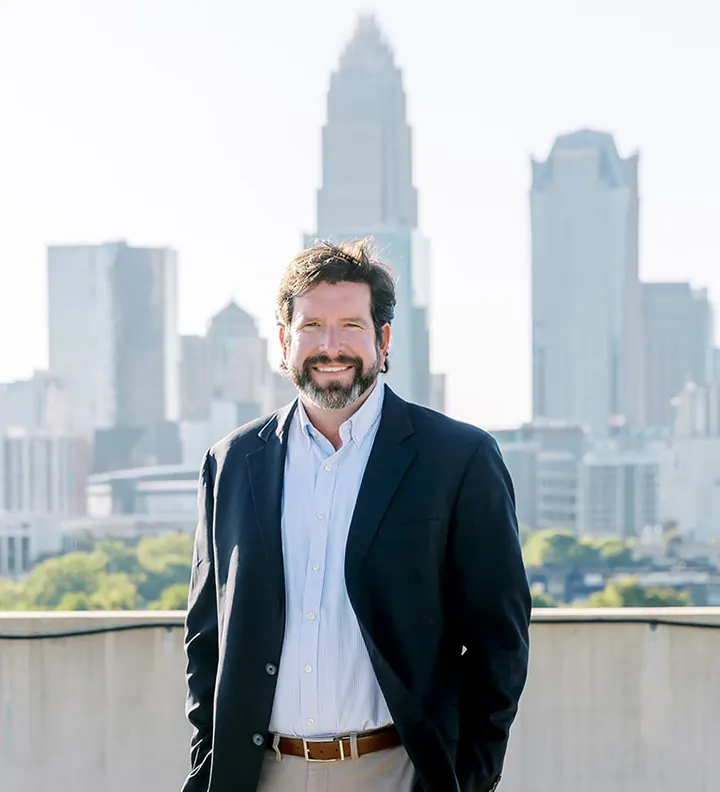 Barrett Fowler, commercial real estate broker, with the Uptown Charlotte skyline behind him